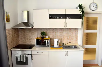 a kitchen with white cabinets and a sink at Romantic Bijou Apartment near Old Town! in Prague