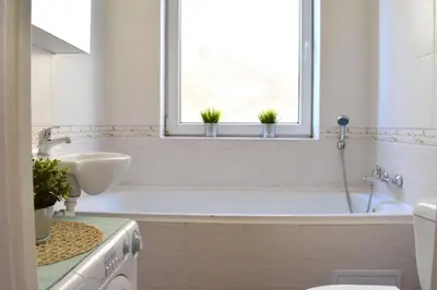 a bathroom with a tub and a sink and a window at Romantic Bijou Apartment near Old Town! in Prague