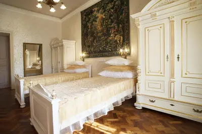 a bedroom with two beds and a painting on the wall at Art Apartments Celakovskeho Sady in Prague