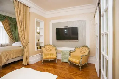 a bedroom with two chairs and a bed and a tv at Art Apartments Celakovskeho Sady in Prague