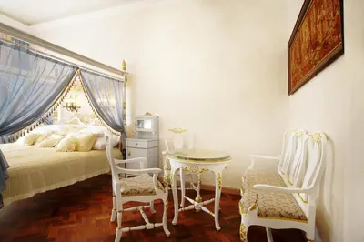 a bedroom with a bed and a table and chairs at Art Apartments Celakovskeho Sady in Prague