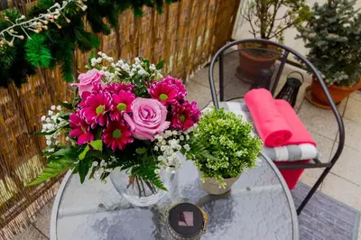 a vase of pink flowers sitting on a glass table at Old Town Studio Apartment in Prague