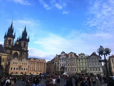 a crowd of people walking around a city with a clock tower at Old Town Studio Apartment in Prague