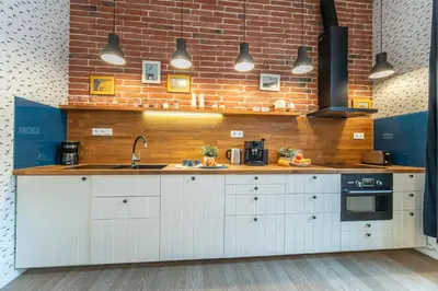 a kitchen with white cabinets and a brick wall at A Prague Apartments - Lesser Town in Prague