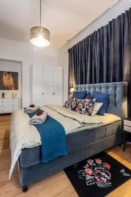 a bedroom with a large bed with a blue headboard at A Prague Apartments - Lesser Town in Prague