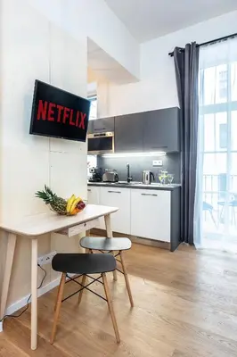 a kitchen with a table and two stools in a kitchen at A Prague Apartments - Lesser Town in Prague