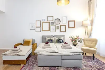 a bedroom with two beds and a chair at A Prague Apartments - Lesser Town in Prague