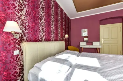 a bedroom with a bed and a pink wall at Prague Locals Monastery Apartments in Prague