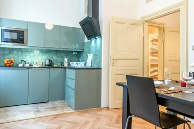 a kitchen with blue cabinets and a table with a chair at Prague Locals Monastery Apartments in Prague