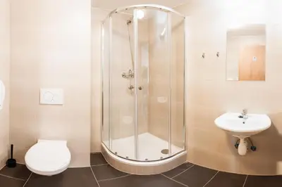 a bathroom with a shower and a toilet and a sink at Hostel Mandarinka in Prague