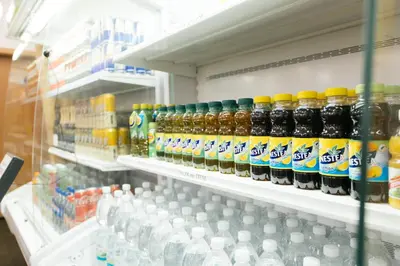 a store shelf filled with bottles of soda and water at Hostel Mandarinka in Prague