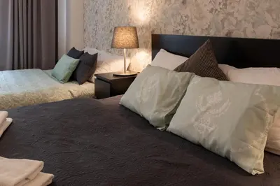 a bedroom with two beds with pillows and a lamp at Luxury apartment in prime location in Prague