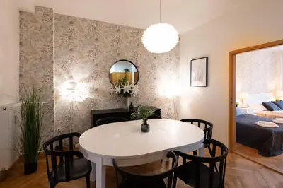 a dining room and living room with a white table and chairs at Luxury apartment in prime location in Prague
