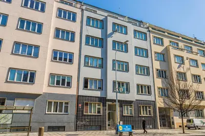 a man standing in front of a large building at Business Studio Andel, 10 min to Centre, NETFLIX, Paid Parking in Prague