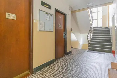 a hallway with a door and stairs in a building at Business Studio Andel, 10 min to Centre, NETFLIX, Paid Parking in Prague