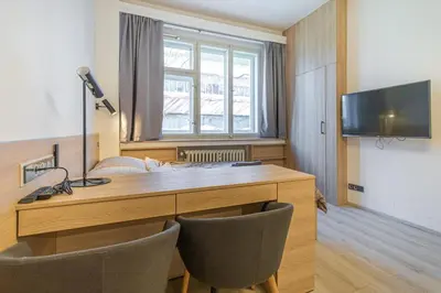 a room with a desk with two chairs and a television at Business Studio Andel, 10 min to Centre, NETFLIX, Paid Parking in Prague