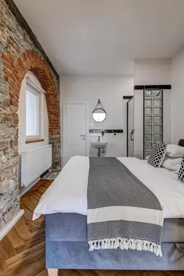 a bedroom with a large bed and a brick wall at Design Pension Twenty 20 in Poděbrady
