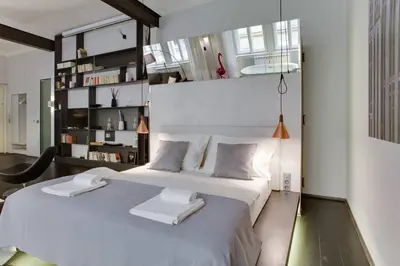 a bedroom with a large white bed with two towels on it at BRIGHT Prague Havelská in Prague