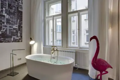a bathroom with a bath tub and a pink flamingo at BRIGHT Prague Havelská in Prague