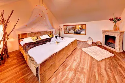 a bedroom with a large bed and a fireplace at Štiřínská stodola u Prahy in Kamenice