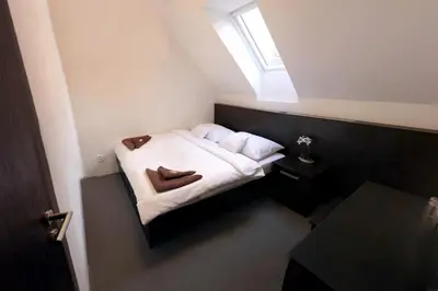 a small bedroom with a small bed with a window at Štiřínská stodola u Prahy in Kamenice