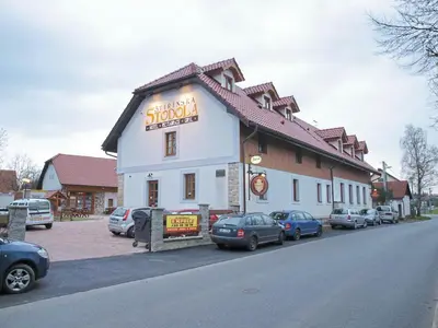 a building with cars parked in a parking lot at Štiřínská stodola u Prahy in Kamenice