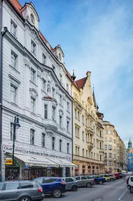 a city street with cars parked in front of buildings at Kaprova - Old Town Apartments in Prague