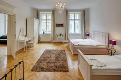 a bedroom with two beds and a chandelier at Kaprova - Old Town Apartments in Prague