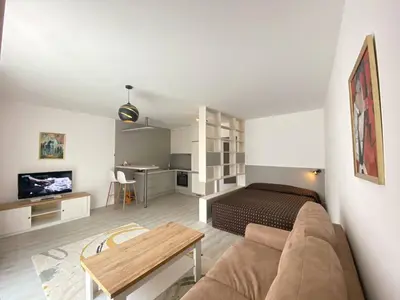 a living room with a bed and a couch and a table at Seven days Smíchov in Prague