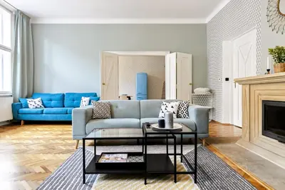 a living room with a blue couch and a table at Cubistic Residence Eliska / Jewish Quarter / Old Town in Prague