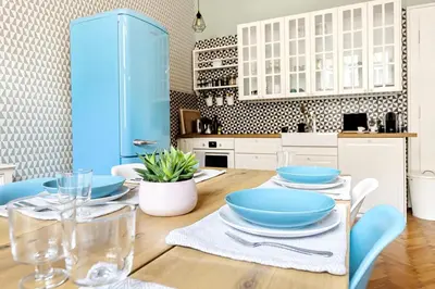 a kitchen with a wooden table with blue bowls on it at Cubistic Residence Eliska / Jewish Quarter / Old Town in Prague