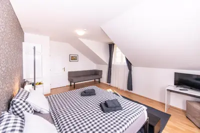 a living room with a bed and a television at Penzion Stříbrná Lhota in Mníšek pod Brdy