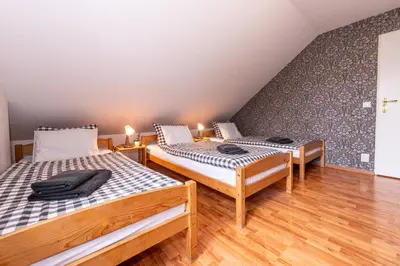 two twin beds in a room with wooden floors at Penzion Stříbrná Lhota in Mníšek pod Brdy