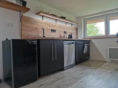 a kitchen with black cabinets and white appliances at Apartmány Svatá in Svatá