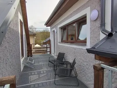 a patio with two chairs and a window on a house at Apartmány Svatá in Svatá