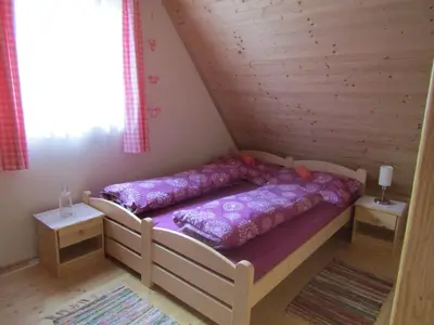 a bedroom with a bed in a wooden cabin at rekreační dům levandule in Jince