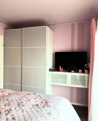 a bedroom with a bed and a flat screen tv at Krejcarek Garden Apartment in Prague