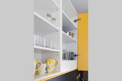 a kitchen with white shelves and yellow doors at Design Studio Anděl, All Historical Sights Walkable in Prague