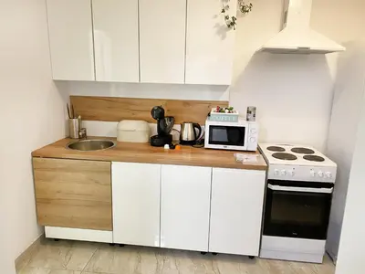 a small kitchen with white cabinets and a microwave at Fano Apartments Old Town Prague in Prague