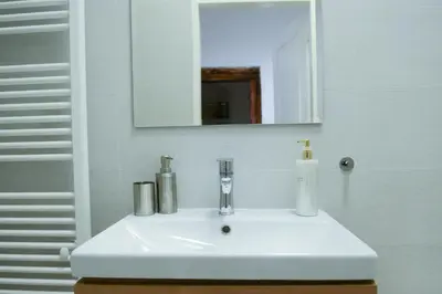 a white sink in a bathroom with a mirror at Fano Apartments Old Town Prague in Prague