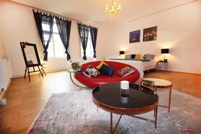 a living room with a red couch and a bed at Fano Apartments Old Town Prague in Prague