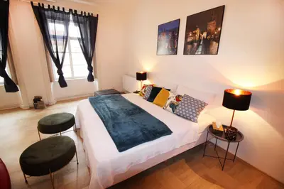 a bedroom with a large bed with two stools at Fano Apartments Old Town Prague in Prague