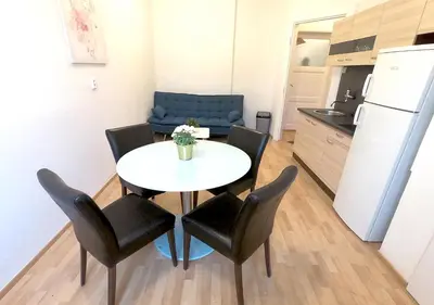 a small apartment with a table and chairs in a kitchen at MIRON Apartman 1 in Prague