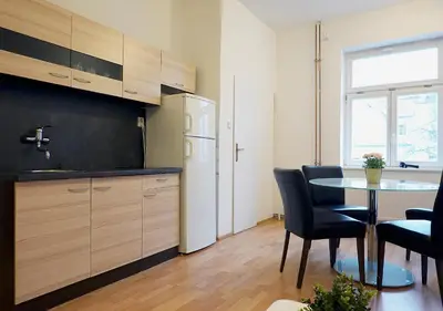 a kitchen with a table and chairs and a refrigerator at MIRON Apartman 1 in Prague
