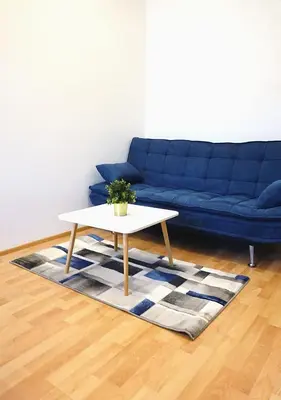 a living room with a blue couch and a table at MIRON Apartman 1 in Prague