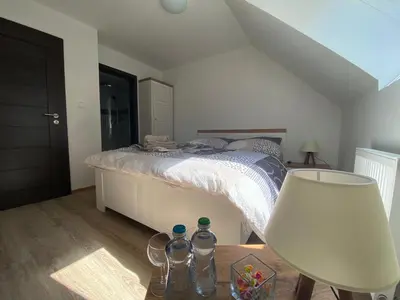 a bedroom with a bed and a table with a lamp at Penzion U Adama in Karlštejn