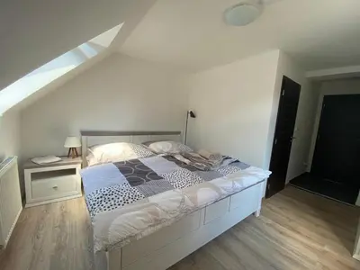 a white bedroom with a bed and a window at Penzion U Adama in Karlštejn