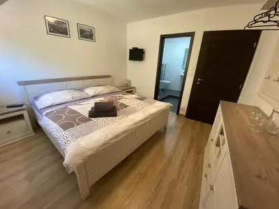a bedroom with a bed with a wooden floor at Penzion U Adama in Karlštejn