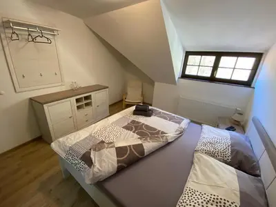 a attic bedroom with two beds and a window at Penzion U Adama in Karlštejn