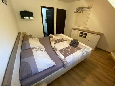 a large bed in a room with a television at Penzion U Adama in Karlštejn